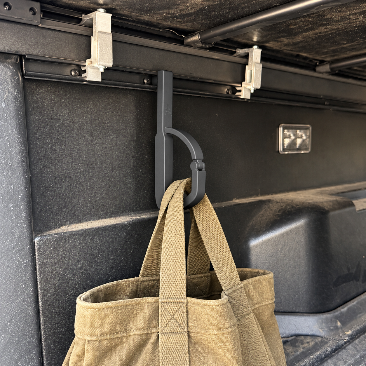 J-Hook mounted in the bed rail holding a canvas bag